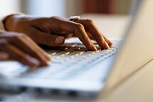 Mixed race woman typing on keyboard