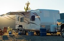 RV in the wilderness around with a setting sun on the horizon