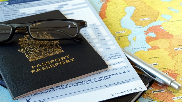 Canadian passport and glasses sitting on top of a map of Europe