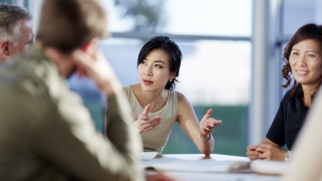 Woman leading a discussion with other businesspeople in boardroom