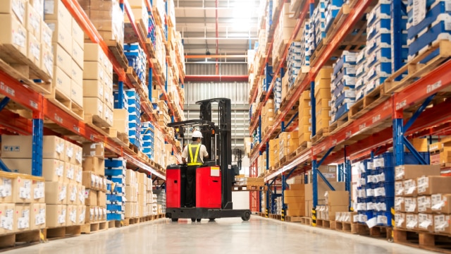 Person driving forklift in warehouse