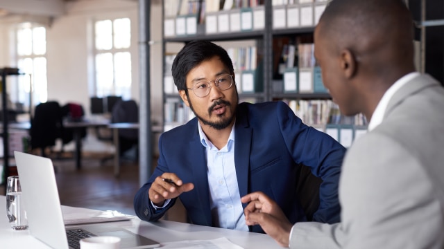 Two businessmen having a conversation in an office