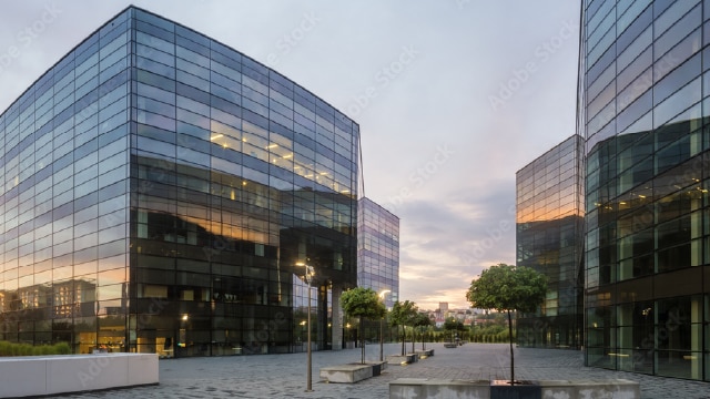 Glass office buildings surrounded by courtyard with trees