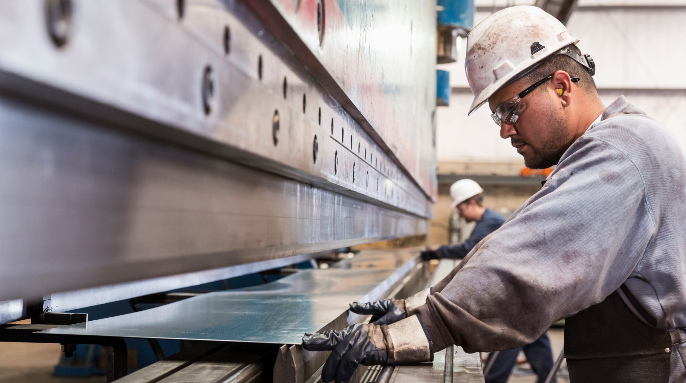 Worker in factory working with sheet metal